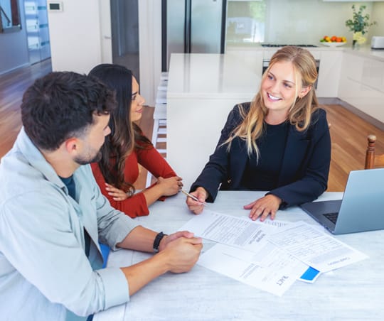 Young couple with Young couple sitting across table from real estate agent